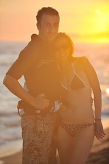 Image showing surf couple posing at beach on sunset