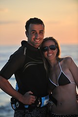 Image showing surf couple posing at beach on sunset