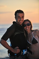 Image showing surf couple posing at beach on sunset