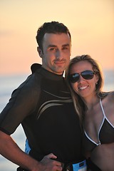 Image showing surf couple posing at beach on sunset