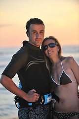 Image showing surf couple posing at beach on sunset