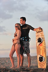 Image showing surf couple posing at beach on sunset