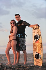 Image showing surf couple posing at beach on sunset