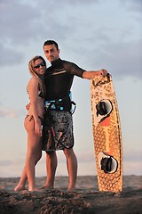 Image showing surf couple posing at beach on sunset