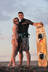 Image showing surf couple posing at beach on sunset