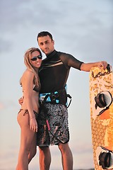 Image showing surf couple posing at beach on sunset