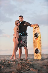 Image showing surf couple posing at beach on sunset