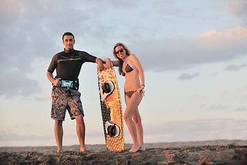 Image showing surf couple posing at beach on sunset