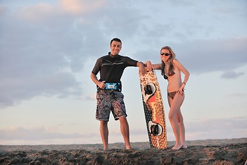 Image showing surf couple posing at beach on sunset