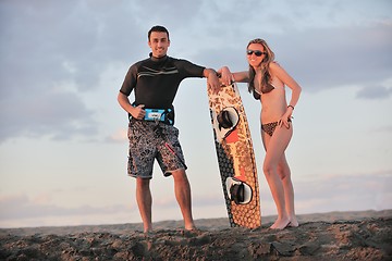 Image showing surf couple posing at beach on sunset