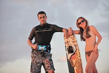 Image showing surf couple posing at beach on sunset