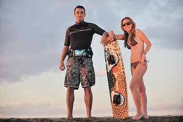 Image showing surf couple posing at beach on sunset