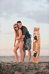 Image showing surf couple posing at beach on sunset