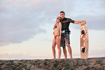 Image showing surf couple posing at beach on sunset