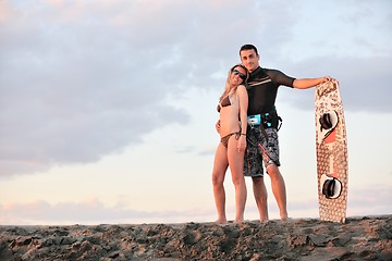 Image showing surf couple posing at beach on sunset