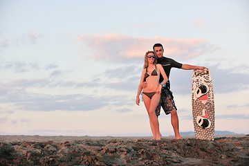 Image showing surf couple posing at beach on sunset