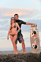 Image showing surf couple posing at beach on sunset