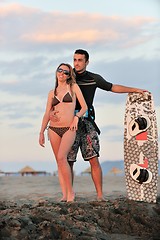 Image showing surf couple posing at beach on sunset