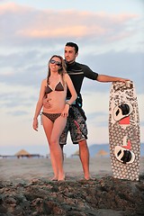 Image showing surf couple posing at beach on sunset