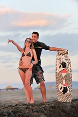 Image showing surf couple posing at beach on sunset