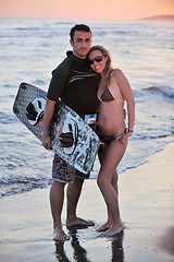 Image showing surf couple posing at beach on sunset