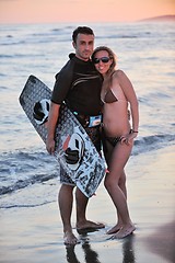 Image showing surf couple posing at beach on sunset