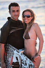 Image showing surf couple posing at beach on sunset