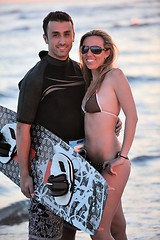 Image showing surf couple posing at beach on sunset