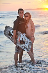 Image showing surf couple posing at beach on sunset