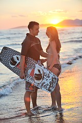 Image showing surf couple posing at beach on sunset