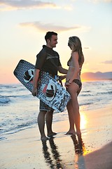 Image showing surf couple posing at beach on sunset