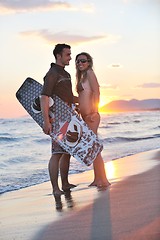 Image showing surf couple posing at beach on sunset