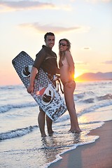 Image showing surf couple posing at beach on sunset