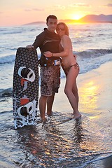 Image showing surf couple posing at beach on sunset