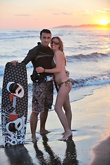 Image showing surf couple posing at beach on sunset