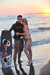 Image showing surf couple posing at beach on sunset