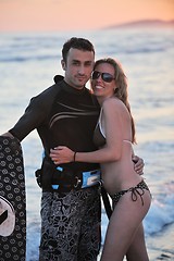 Image showing surf couple posing at beach on sunset