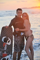 Image showing surf couple posing at beach on sunset