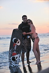 Image showing surf couple posing at beach on sunset