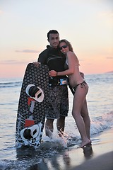 Image showing surf couple posing at beach on sunset