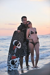 Image showing surf couple posing at beach on sunset