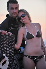 Image showing surf couple posing at beach on sunset