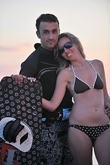 Image showing surf couple posing at beach on sunset