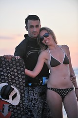 Image showing surf couple posing at beach on sunset