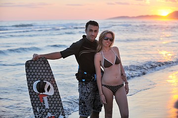 Image showing surf couple posing at beach on sunset