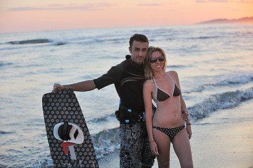 Image showing surf couple posing at beach on sunset