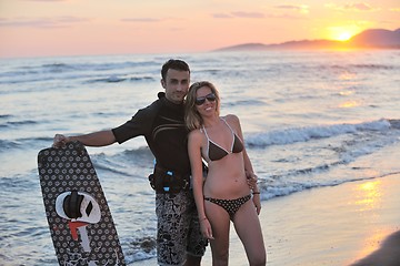 Image showing surf couple posing at beach on sunset
