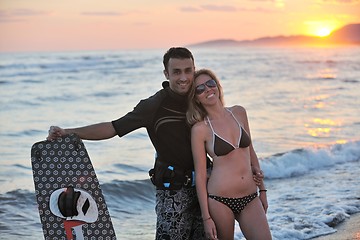 Image showing surf couple posing at beach on sunset