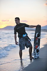 Image showing Portrait of a young  kitsurf  man at beach on sunset