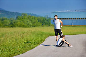 Image showing people doing stretching exercise  after jogging